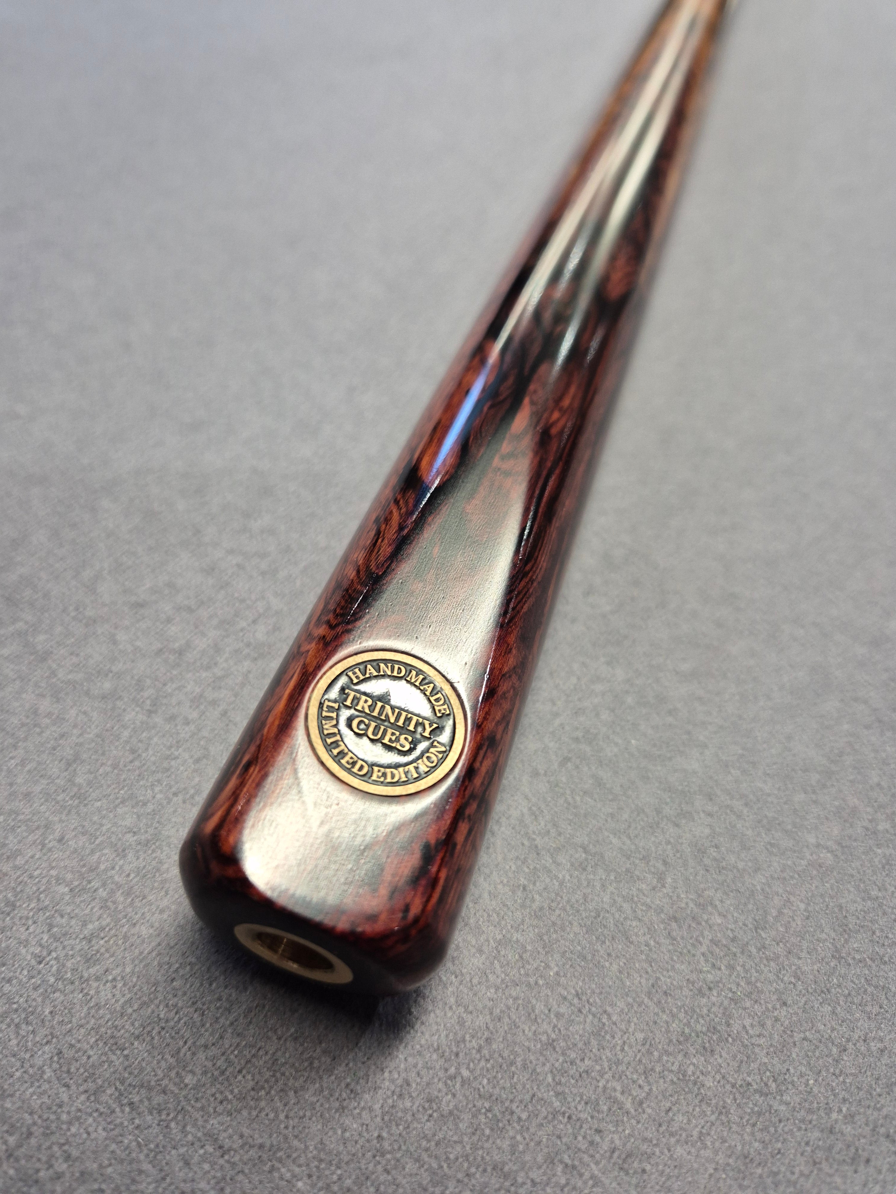 Close-up of a wooden and metal object with a logo on a gray background